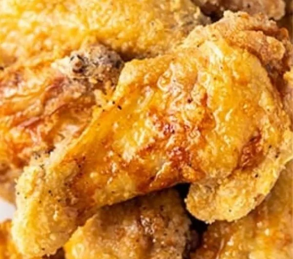 Crispy air fryer chicken wings served with dipping sauce and garnished with herbs