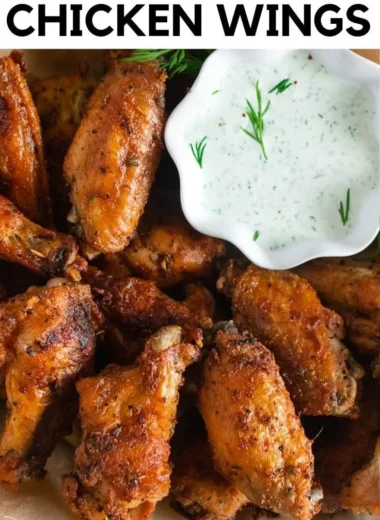 Crispy baked chicken wings on a plate with dipping sauce
