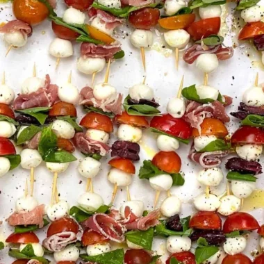 Mini Caprese Salad Skewers with fresh mozzarella, tomatoes, and basil on a plate