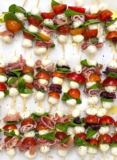 Mini Caprese Salad Skewers with fresh mozzarella, tomatoes, and basil on a plate