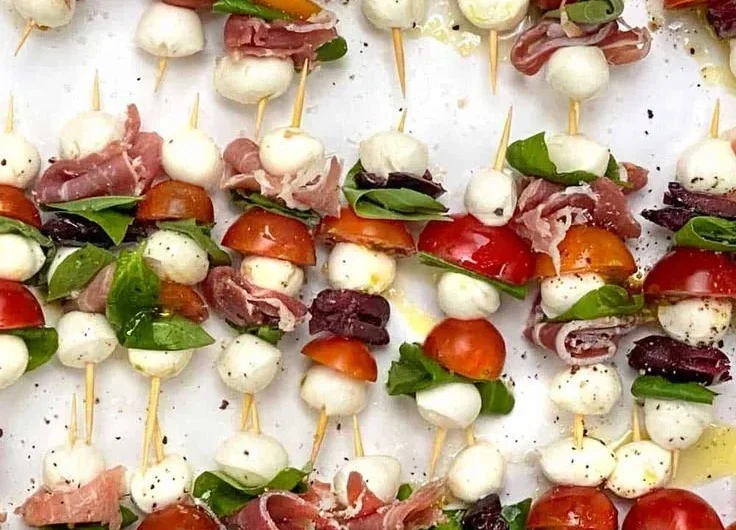 Mini Caprese Salad Skewers with fresh mozzarella, tomatoes, and basil on a plate