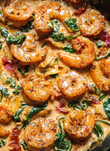 Delicious Tuscan Shrimp with Spinach served on a plate, garnished with herbs.