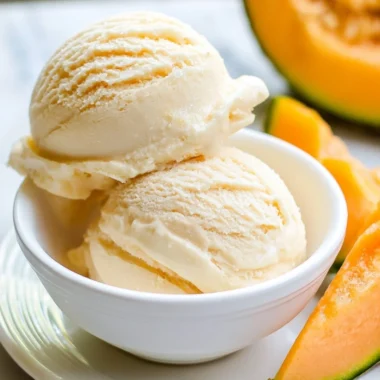 Cantaloupe sea salt ice cream in a bowl with fresh fruit slices