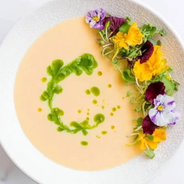 Bowl of chilled peach soup garnished with mint leaves