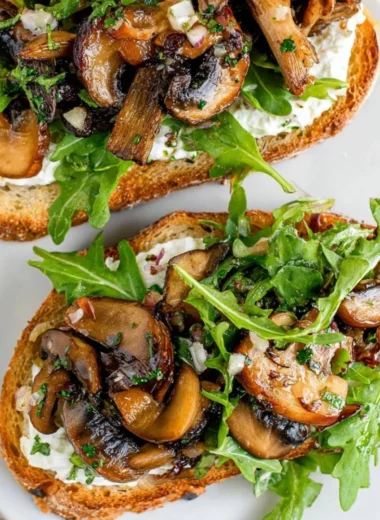 Delicious creamy mushroom toast topped with herbs and cheese