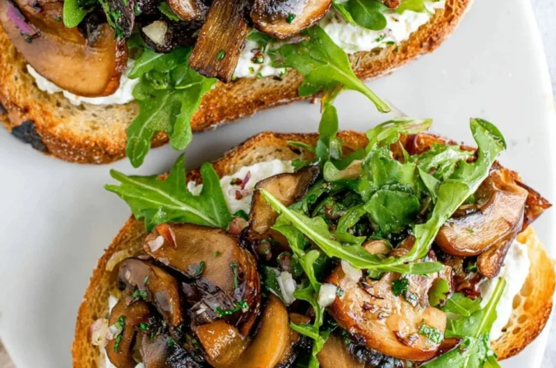 Delicious creamy mushroom toast topped with herbs and cheese