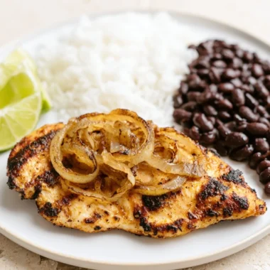Delicious Cuban Grilled Chicken on a plate with herbs and tropical sides