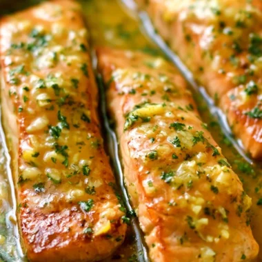 Delicious Garlic Butter Salmon fillet garnished with herbs and lemon slices