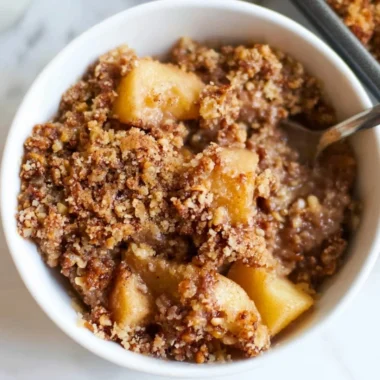 Healthy breakfast apple crumble topped with oats and served in a bowl