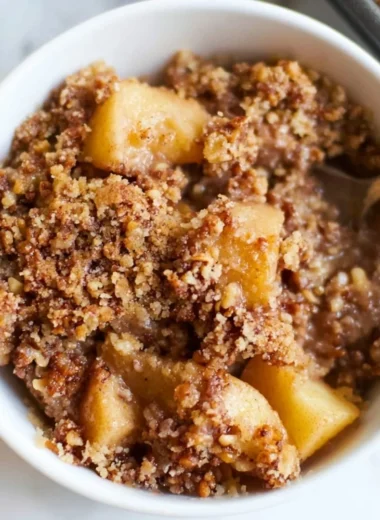 Healthy breakfast apple crumble topped with oats and served in a bowl