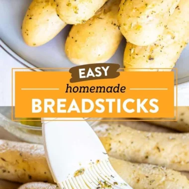Homemade garlic herb breadsticks on a baking tray with herbs and melted butter.