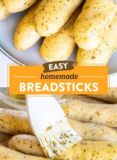 Homemade garlic herb breadsticks on a baking tray with herbs and melted butter.