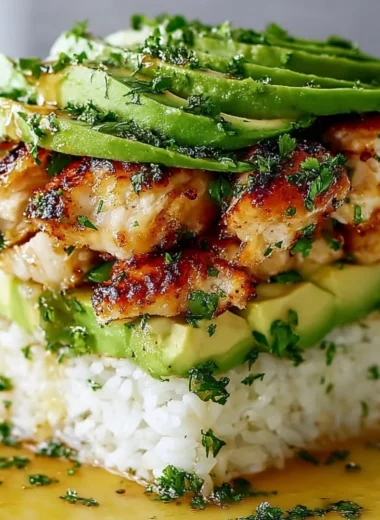 Honey Lime Chicken Avocado Rice Stack garnished with lime slices and avocado.