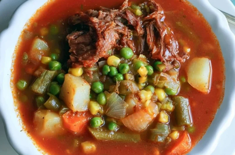 A bowl of hearty vegetable beef soup with colorful vegetables and tender beef pieces.