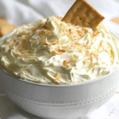 Delicious no bake coconut cream pie dip served in a bowl with coconut flakes on top.