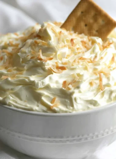 Delicious no bake coconut cream pie dip served in a bowl with coconut flakes on top.