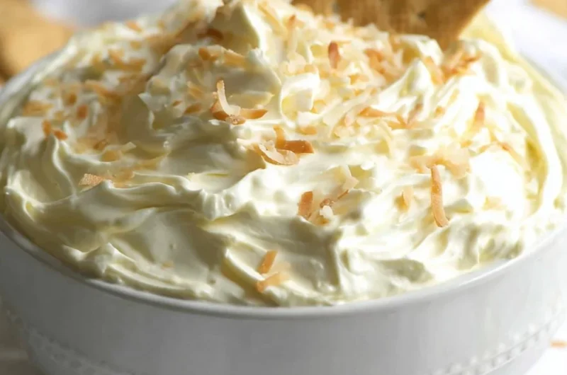 Delicious no bake coconut cream pie dip served in a bowl with coconut flakes on top.