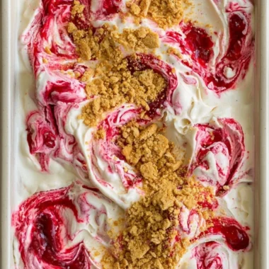 Delicious no churn cherry cheesecake ice cream in a bowl with cherries on top.
