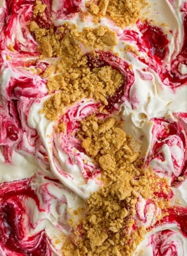 Delicious no churn cherry cheesecake ice cream in a bowl with cherries on top.