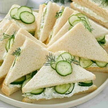Delicious cucumber sandwiches served with fresh ingredients and sides.
