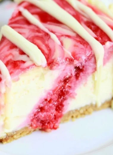 Delicious white chocolate raspberry swirl cheesecake with berry topping