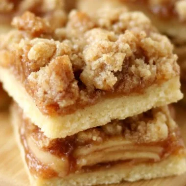 Delicious Apple Crisp Shortbread Bars on a wooden table.