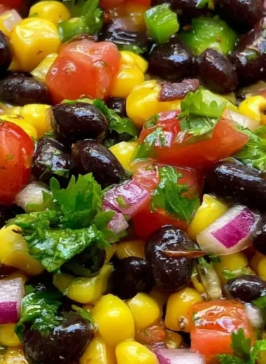 Homemade black bean corn salsa in a colorful bowl with fresh ingredients.