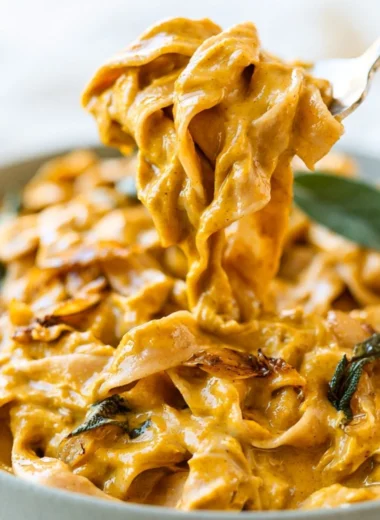 Cozy pumpkin pasta sauce in a bowl with herbs and pasta