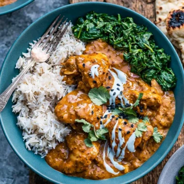 Slow cooker chicken curry served in a bowl with spices and herbs