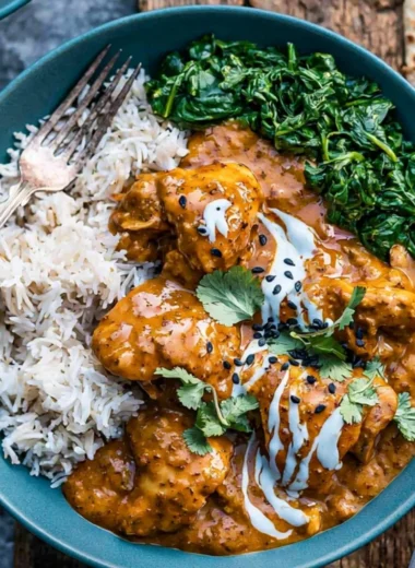 Slow cooker chicken curry served in a bowl with spices and herbs