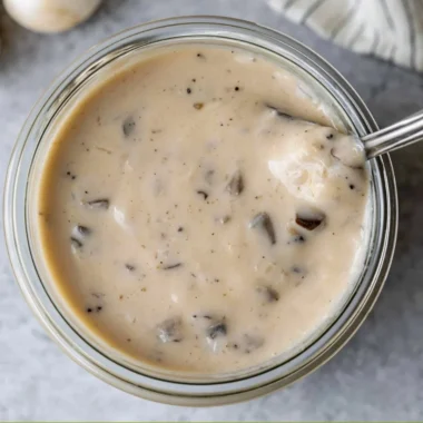 Bowl of creamy mushroom soup garnished with fresh herbs