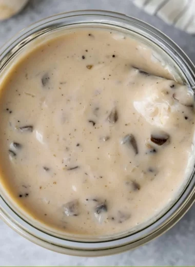 Bowl of creamy mushroom soup garnished with fresh herbs