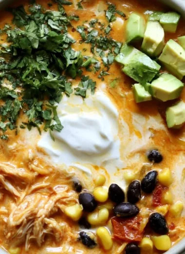 Bowl of creamy chicken enchilada soup garnished with cilantro and cheese
