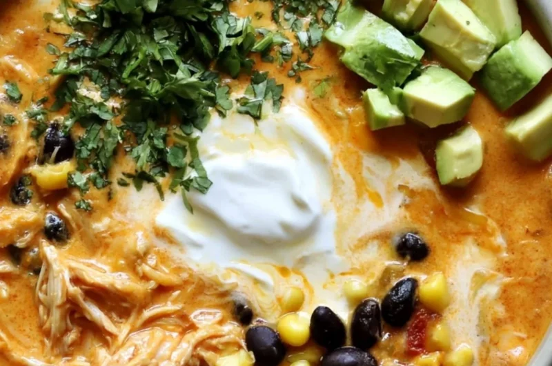 Bowl of creamy chicken enchilada soup garnished with cilantro and cheese