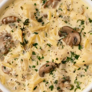 Bowl of creamy chicken soup with Boursin cheese garnished with herbs