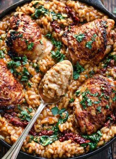 Creamy sun-dried tomato and spinach risotto served with chicken thighs