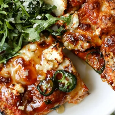 Hot Honey and Goat Cheese Pepperoni Pizza slice on a wooden board