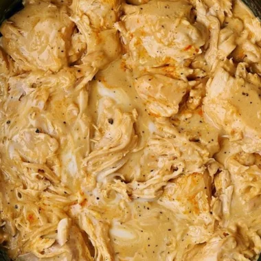 Low cooker chicken breasts served with rich gravy on a plate.