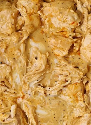 Low cooker chicken breasts served with rich gravy on a plate.