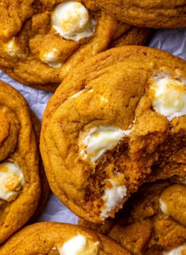 Freshly baked pumpkin white chocolate chip cookies on a rustic wooden table