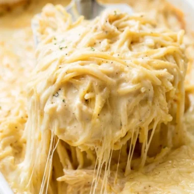 Delicious Ranch Chicken Spaghetti served on a white plate with fresh herbs.
