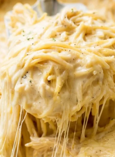 Delicious Ranch Chicken Spaghetti served on a white plate with fresh herbs.