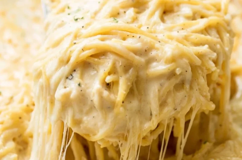 Delicious Ranch Chicken Spaghetti served on a white plate with fresh herbs.