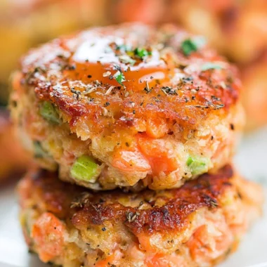 Cozy crispy salmon cakes drizzled with honey sriracha sauce.