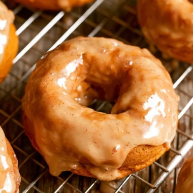 Cozy vegan pumpkin donuts topped with cinnamon sugar on a rustic table