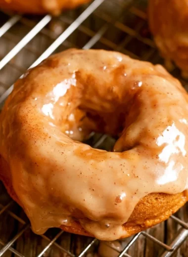 Cozy vegan pumpkin donuts topped with cinnamon sugar on a rustic table