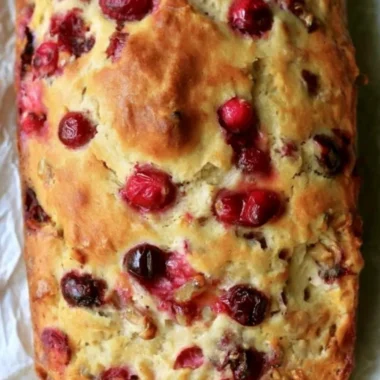 Loaf of Mom's delicious homemade cranberry walnut bread with nuts and berries.